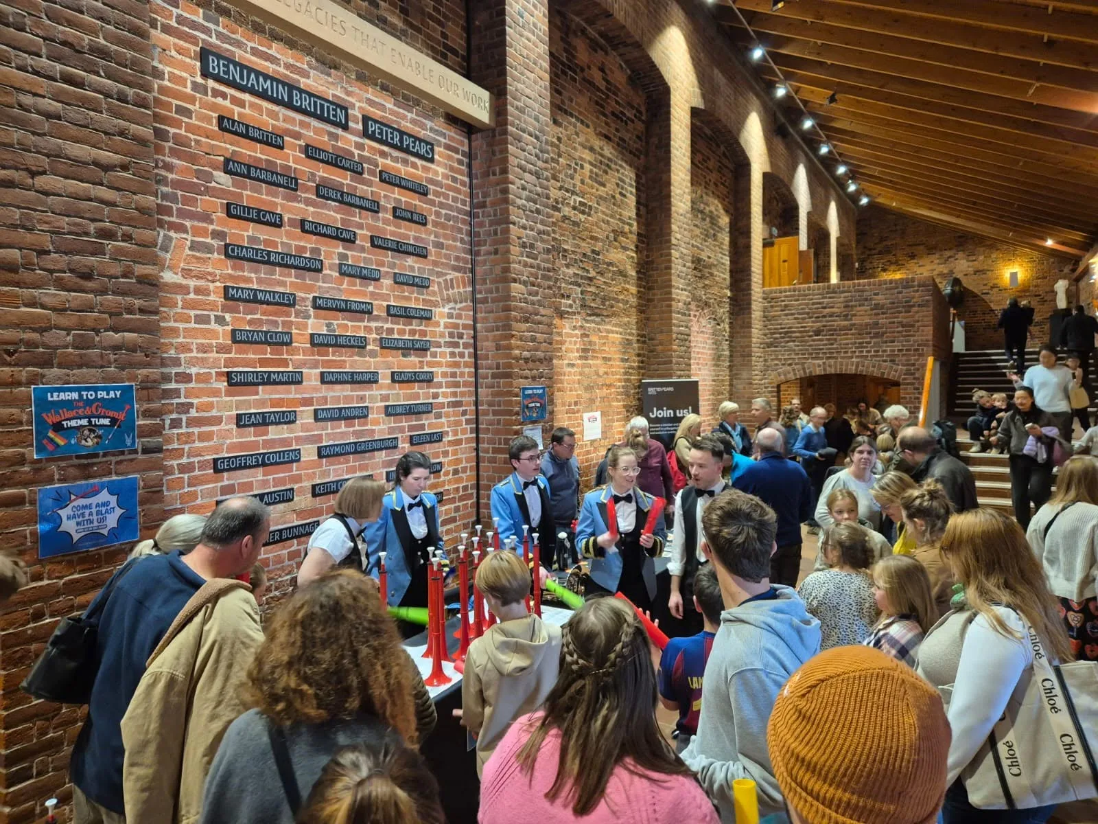 Families trying pBuzz instruments at a KNDS Fairey Band workshop at Snape Maltings
